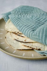 warm corn tortillas under a towel